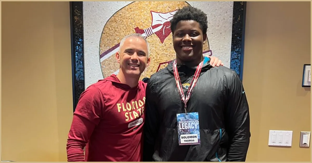 FSU OL commit standing with HC Mike Norvell
